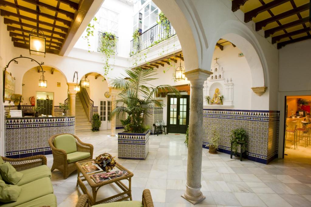 un gran vestíbulo con sillas y mesa en Los Helechos, en Sanlúcar de Barrameda