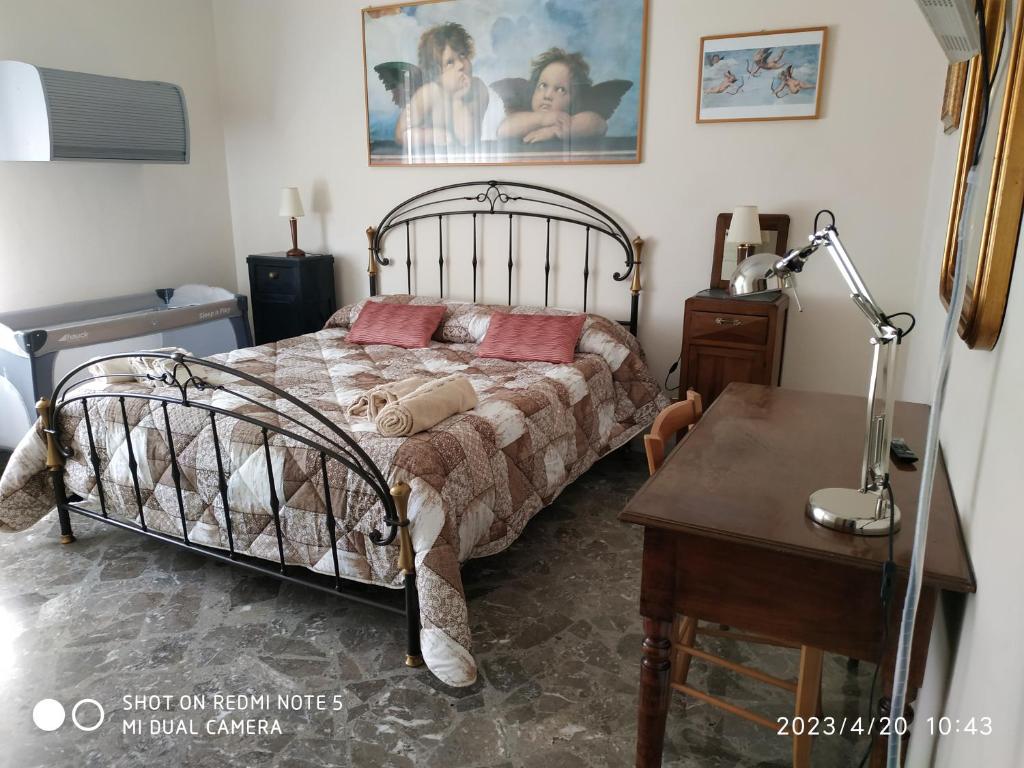 um quarto com uma cama e uma mesa com um candeeiro em HSH Home Sweet Home em Bari