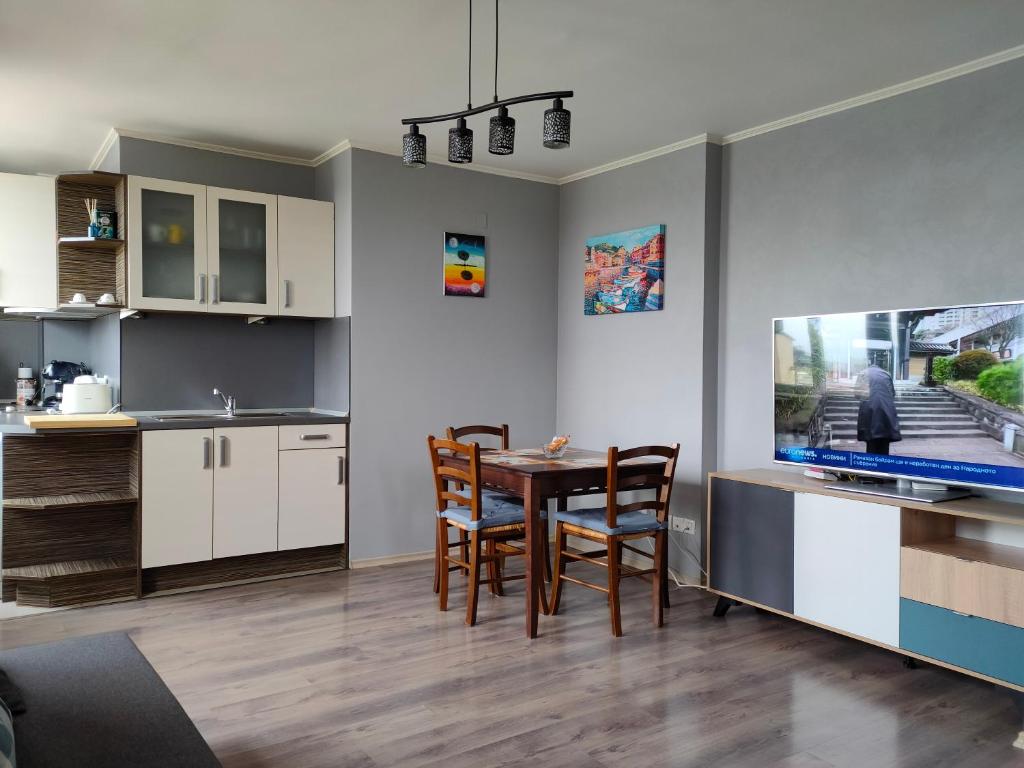 a kitchen and dining room with a table and a tv at Mladost 1 Apartment near the metro in Sofia