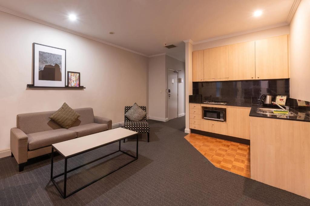 a living room with a couch and a table at Chic 1-bedroom Apartment in Melbourne CBD in Melbourne