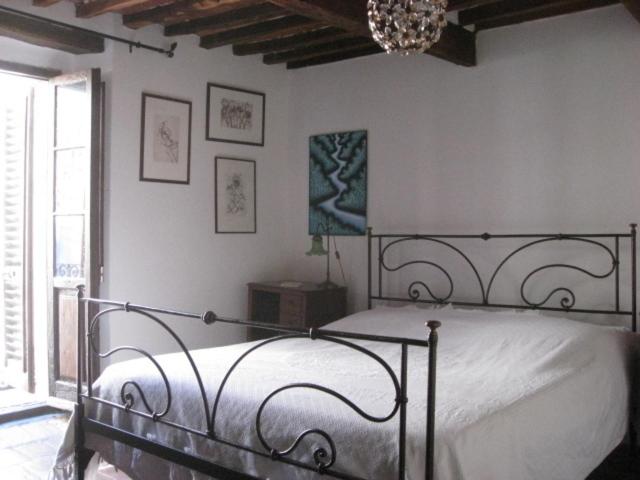 a bedroom with a bed and a chandelier at Una Terrazza sulla maremma in Caldana