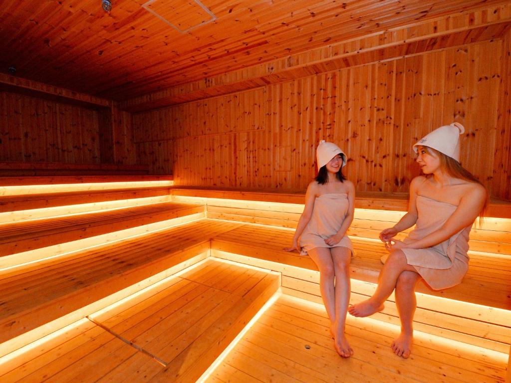 two women are sitting in a sauna at LC Goryokaku Hotel in Hakodate