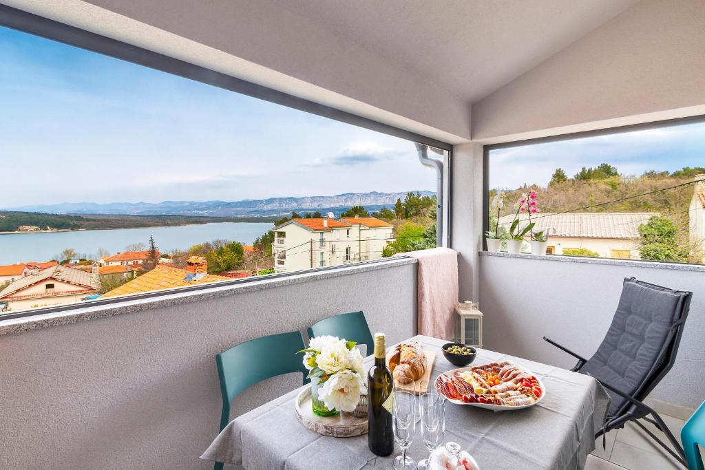 una mesa con platos de comida en un balcón con vistas en Apartments Zabcic, en Soline