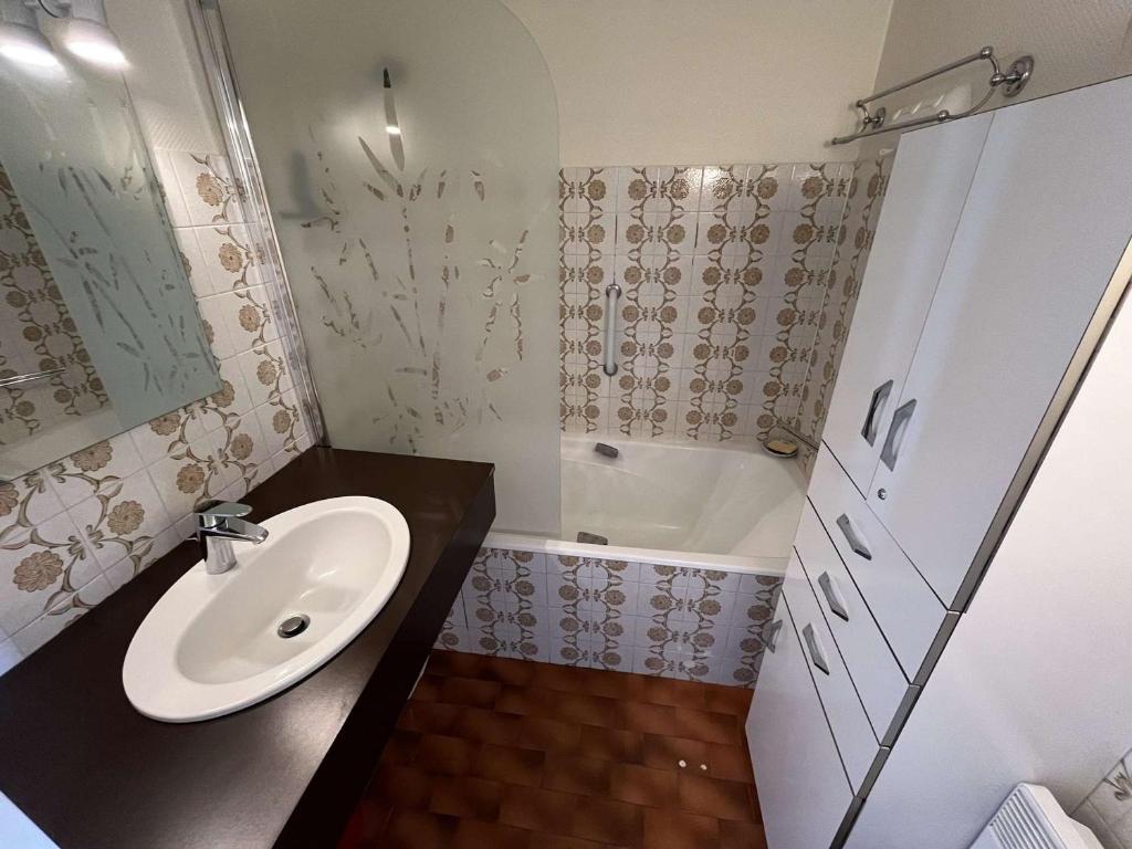 niewielka łazienka z umywalką i wanną w obiekcie Studio cosy à Bénodet: plage, restos, thalasso à pied, balcon et parking privé - FR-1-481-135 w mieście Bénodet