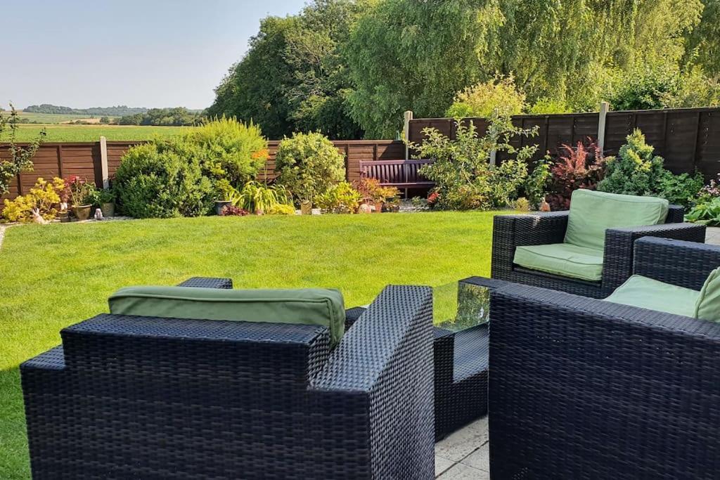 un groupe de chaises en osier assises dans une cour dans l'établissement Self-contained annex with private entrance, double bed, kitchen, bathroom, free car park - Near Cambridge, Duxford Air Museum and Addenbrooke's Hospital, à Cambridge