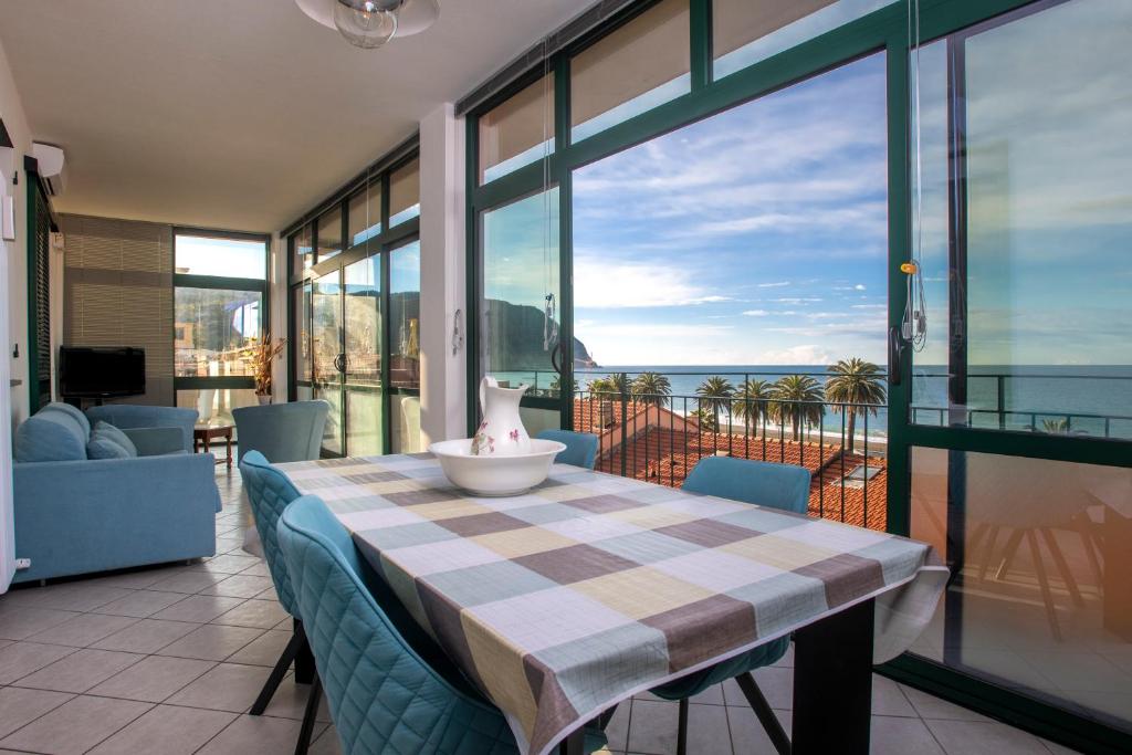 una sala da pranzo con tavolo e vista sull'oceano di 162 - La Veranda Sull'Acqua, Fronte e Vista Mare Riva Trigoso, POSTO AUTO PRIVATO a Sestri Levante