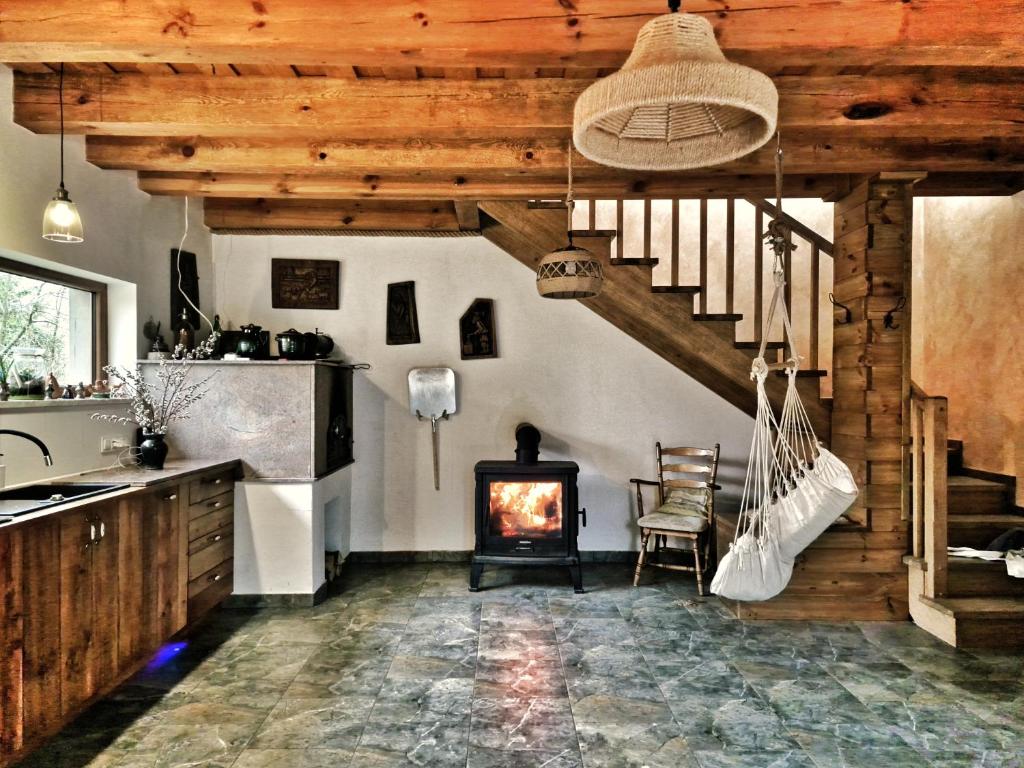 a kitchen with a wooden staircase and a fireplace at Na Przypiecku in Piecki