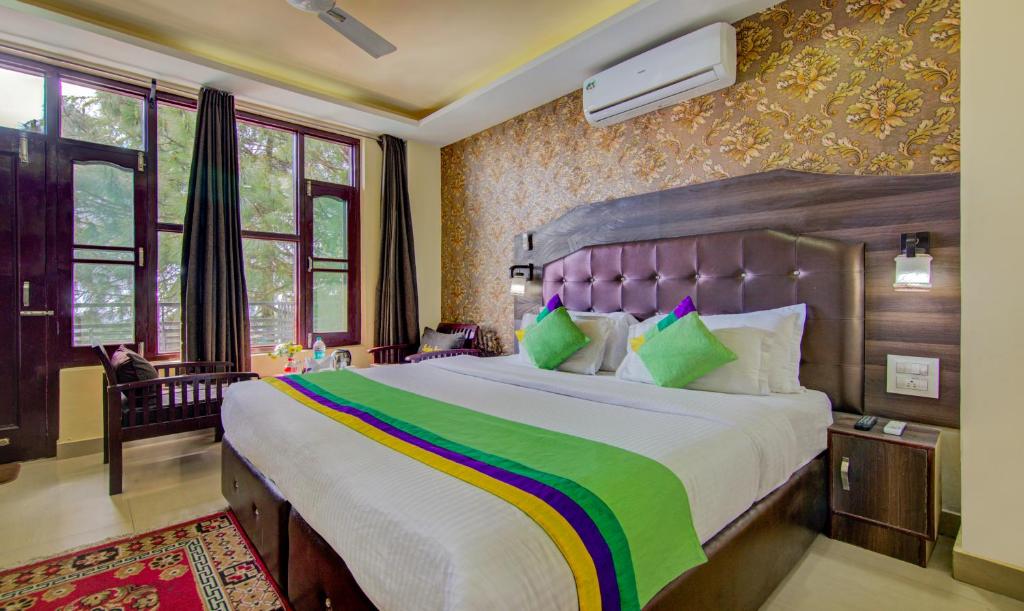 ein Schlafzimmer mit einem großen Bett in einem Zimmer in der Unterkunft Treebo Trend Roshan House in McLeod Ganj