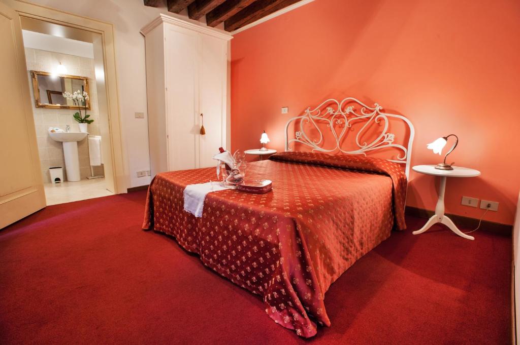 a hotel room with a bed, table and a lamp at Maison San Marco in Venice