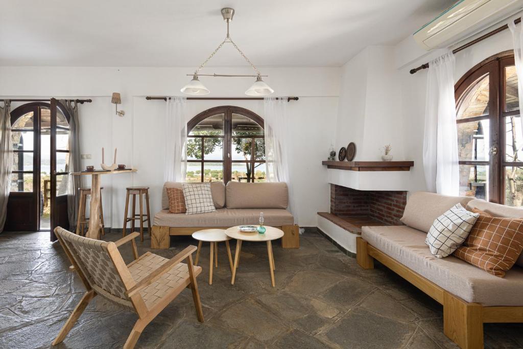 #FLH - Sun Kiss Cottage, Vourvourou في فوروفورو: غرفة معيشة مع أريكة وطاولة