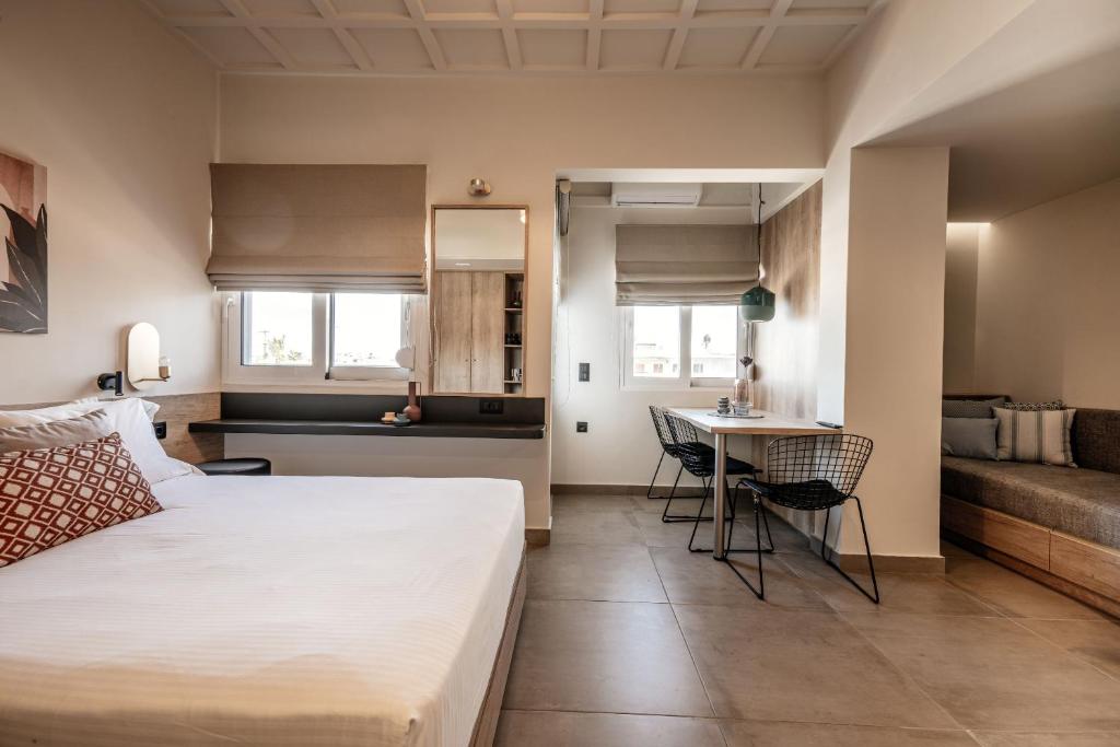 sypialnia z łóżkiem i stołem oraz kuchnia w obiekcie Vinnies Homes w Heraklionie