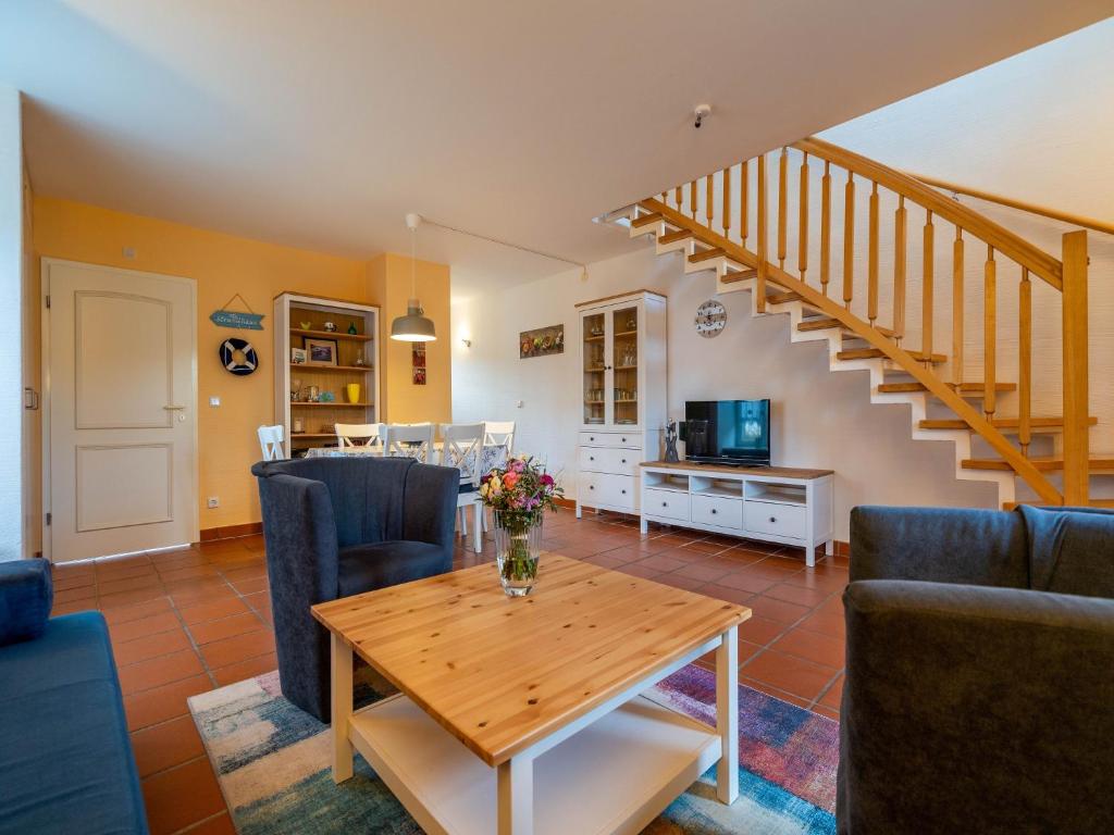 un salon avec une table et des chaises et un escalier dans l'établissement Feriendorf Rugana - Komfort Appartement mit 2 Schlafzimmern und Terrasse A61, à Dranske