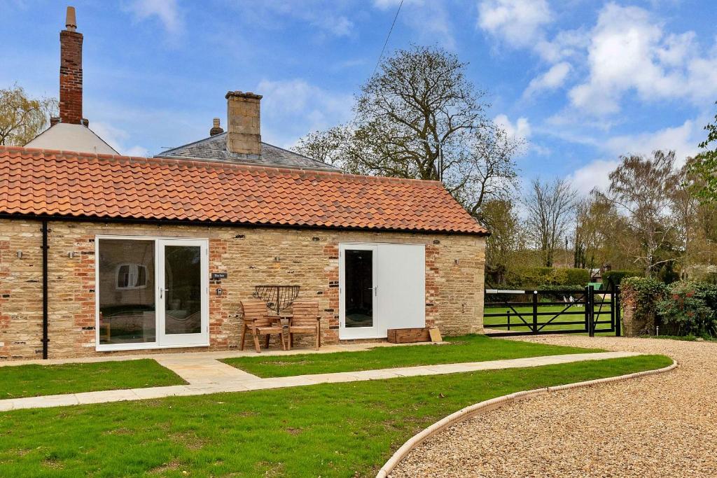 una casa de ladrillo con una mesa y sillas delante de ella en Finest Retreats - The Sett en Stamford