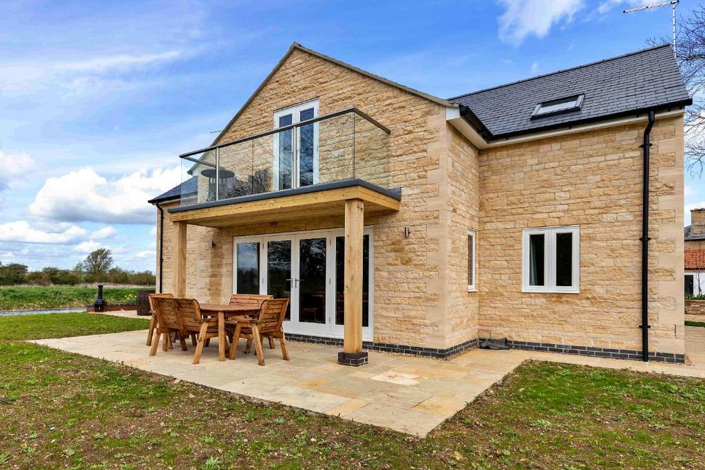 a house with a table and chairs in front of it at Finest Retreats - The Roost in Stamford