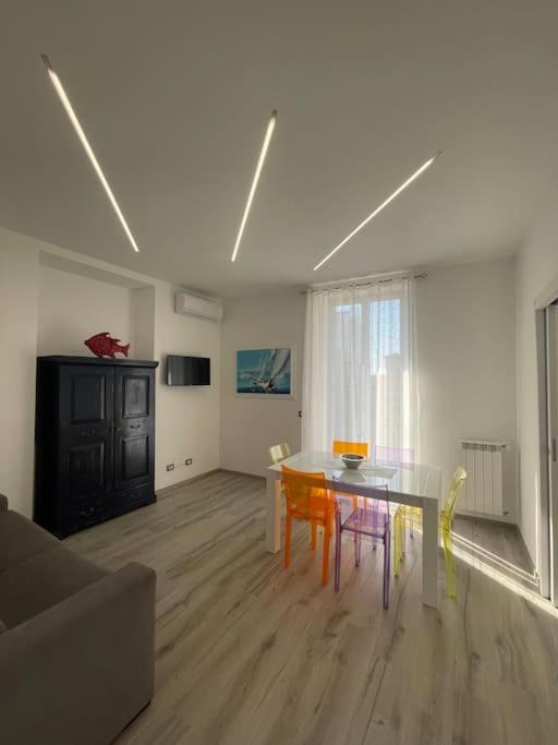 een woonkamer met een tafel en stoelen bij Appartamento Dipinto di blu- Vista Mare! in Nettuno