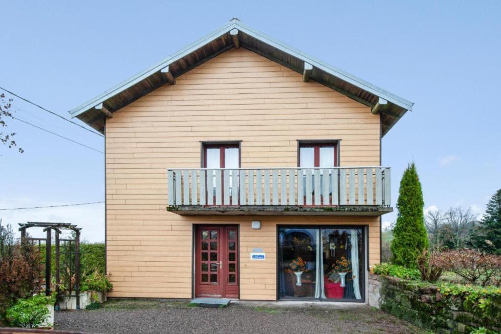 a house with a balcony on top of it at Location Vacances Des 4 Vents in Girmont-Val-dʼAjol