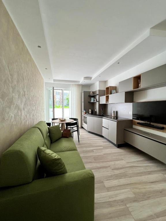 a living room with a green couch and a kitchen at Vilu Suite Centro in Polignano a Mare