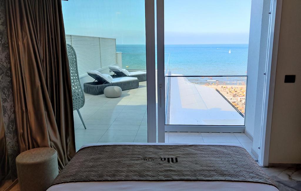 a bedroom with a view of the ocean from a balcony at Ale Suite Sea Side View - Hotel Arizona in Riccione