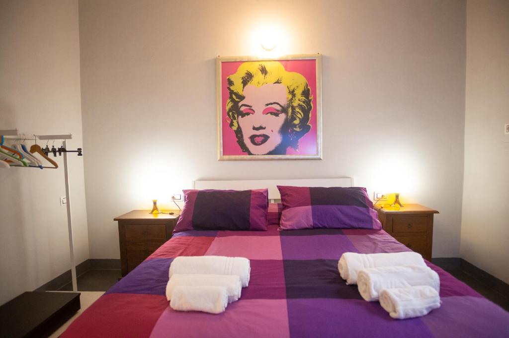 a bedroom with a purple bed with two white pillows at B&Big Prato in Prato