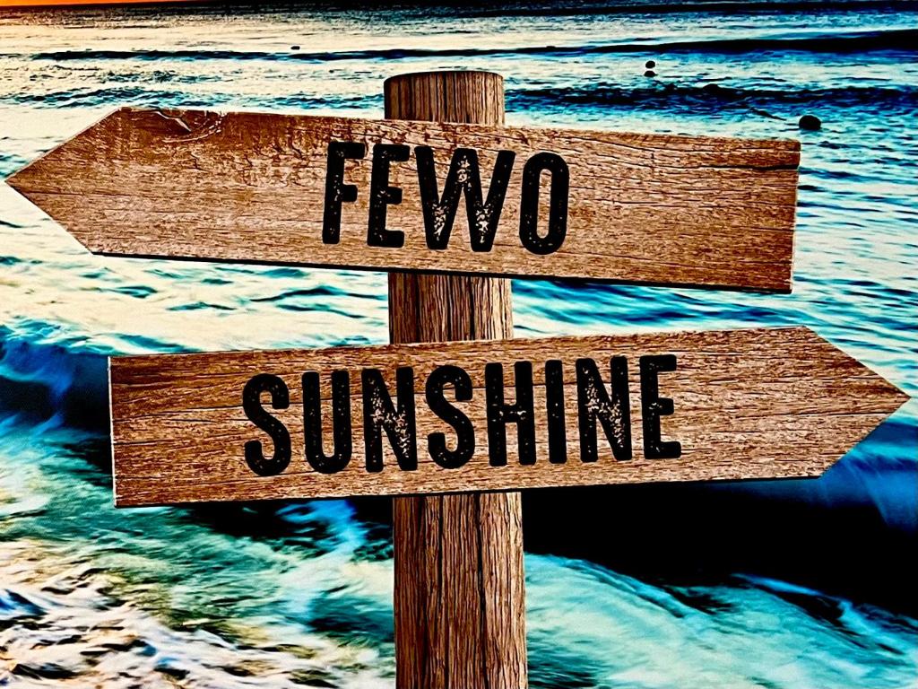 una señal de madera con dos signos que dicen fiebre y sol en FeWo Sunshine en Heringsdorf