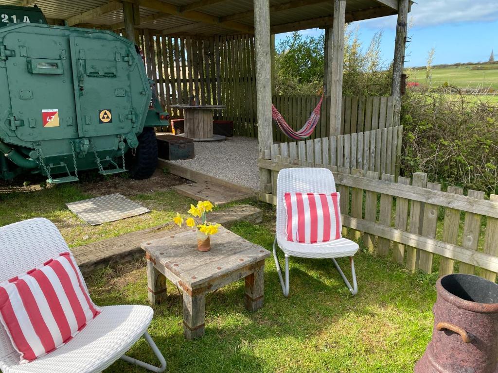 a couple of chairs and a table and a military vehicle at Stunning views & sunrises from Sally Saracen in St Ives