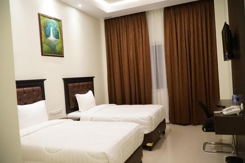 Kirei Hotel في Bonthain: غرفه فندقيه سريرين وتلفزيون