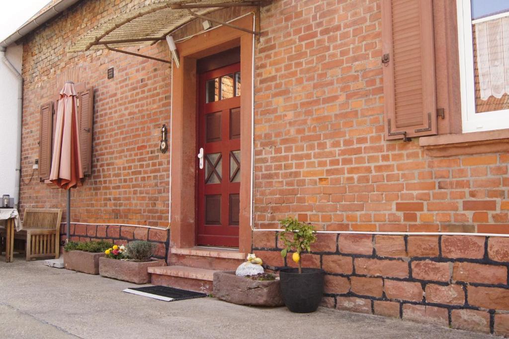 un edificio de ladrillo con una puerta roja y una sombrilla en Ferienhaus Gerlach, en Essingen