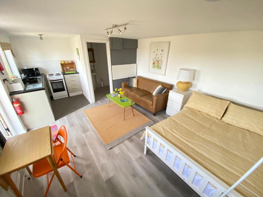 1 dormitorio con 1 cama grande y sala de estar en The Little Cabin, en St Ives