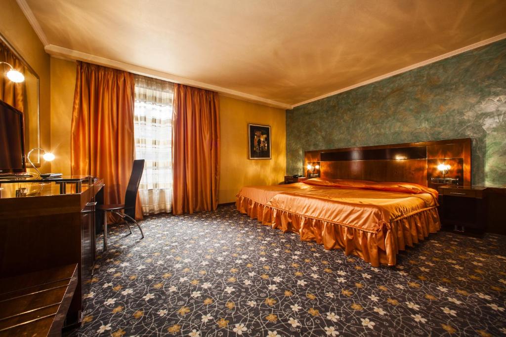 a hotel room with a bed and a desk at Hotel Anel in Sofia