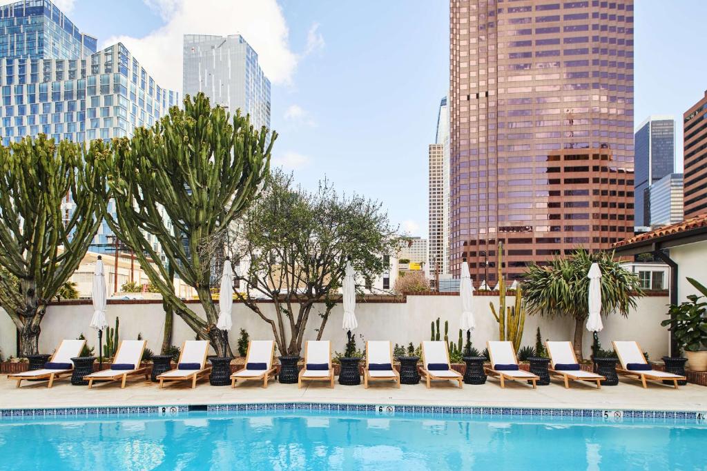 a pool with chaise lounge chairs next to a building at Hotel Figueroa, Unbound Collection by Hyatt in Los Angeles