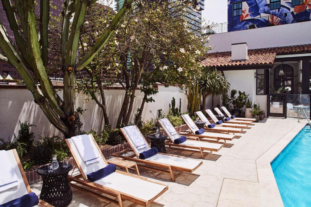 a row of lounge chairs next to a swimming pool at Hotel Figueroa, Unbound Collection by Hyatt in Los Angeles