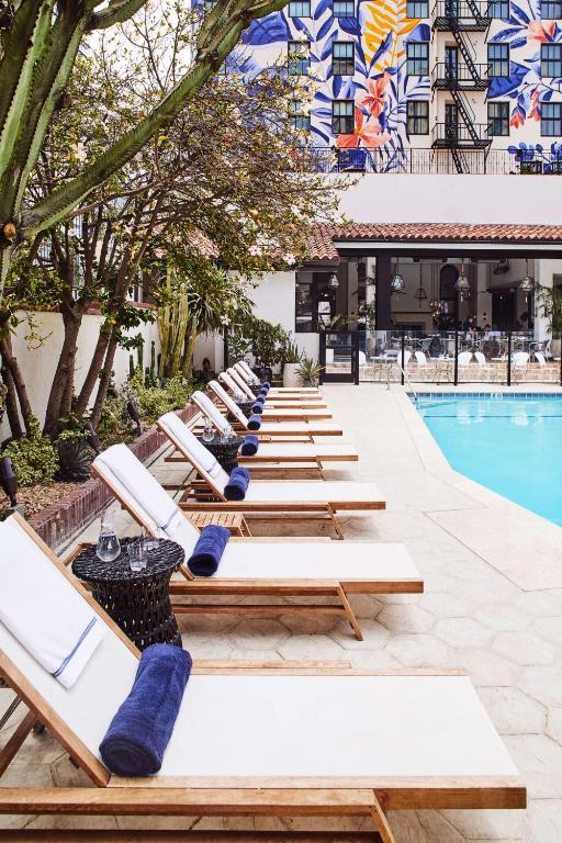 a row of lounge chairs next to a pool at Hotel Figueroa, Unbound Collection by Hyatt in Los Angeles