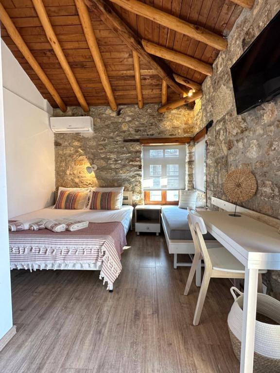 a bedroom with two beds and a stone wall at Casa La Bohema in Afitos