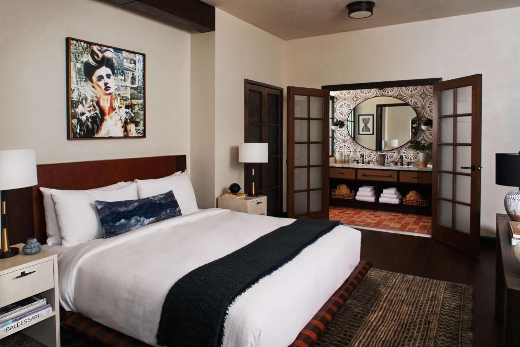 a bedroom with a large bed and a large mirror at Hotel Figueroa, Unbound Collection by Hyatt in Los Angeles