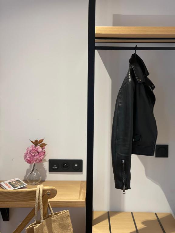Eine schwarze Lederjacke hängt auf einem Regal neben einem Schreibtisch. in der Unterkunft Gîte Les 27 in Saint-Denis-le-Ferment