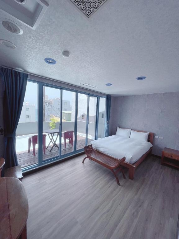 a bedroom with a bed and a large window at Blue Sea Inn in Eluan