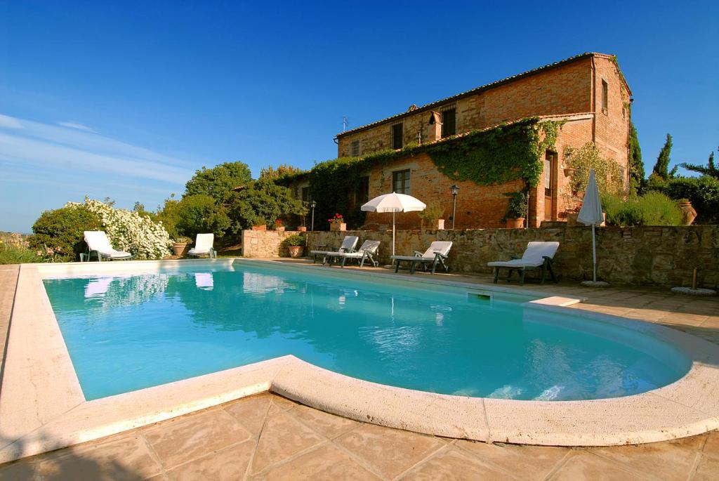 una grande piscina di fronte a un edificio di Tenuta Santagnese a Montepulciano