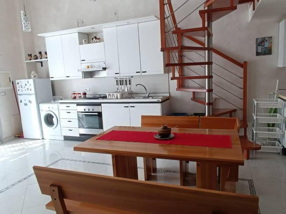 eine Küche mit einem Tisch und eine Küche mit einer Treppe in der Unterkunft Casa Vacanza Raggio di sole in Giovinazzo
