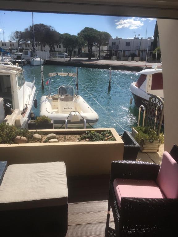 - une vue sur la piscine avec un bateau dans l'eau dans l'établissement Marina au bord de l'eau avec appontement bateau, au Grau-du-Roi