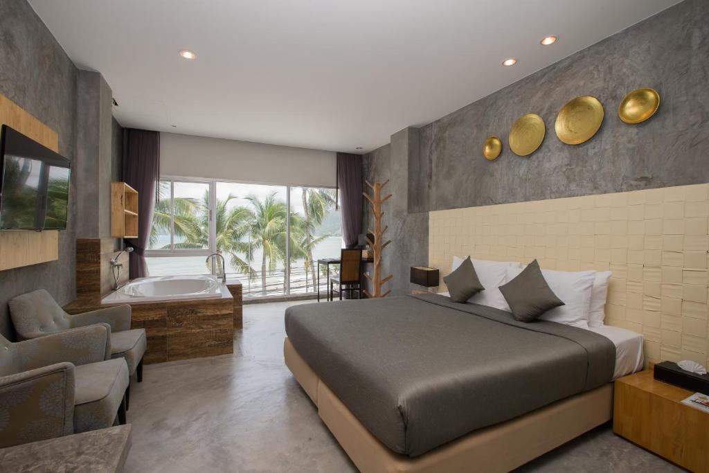 um quarto com uma cama e uma banheira ao lado de uma casa de banho em Patong Signature Boutique Hotel em Praia de Patong