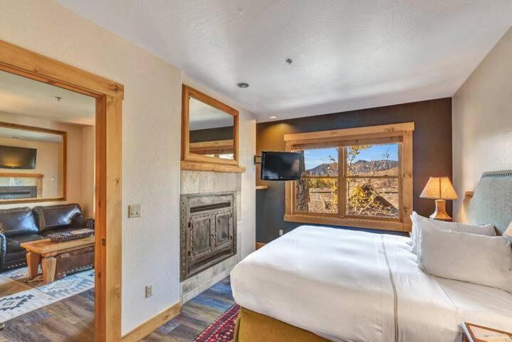 a bedroom with a large bed and a fireplace at Have It All Ski in out Affordable Too in Telluride