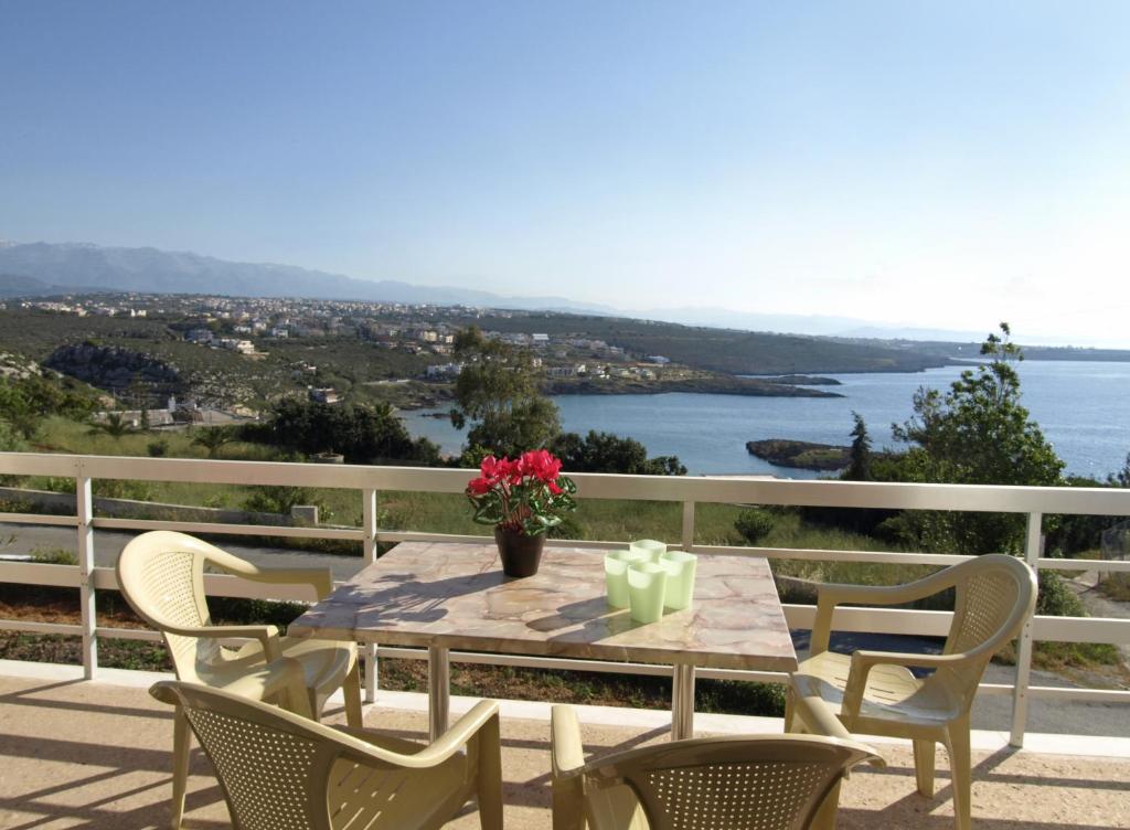 a table and chairs on a balcony with a view of the water at Villas Michalis in Chorafakia