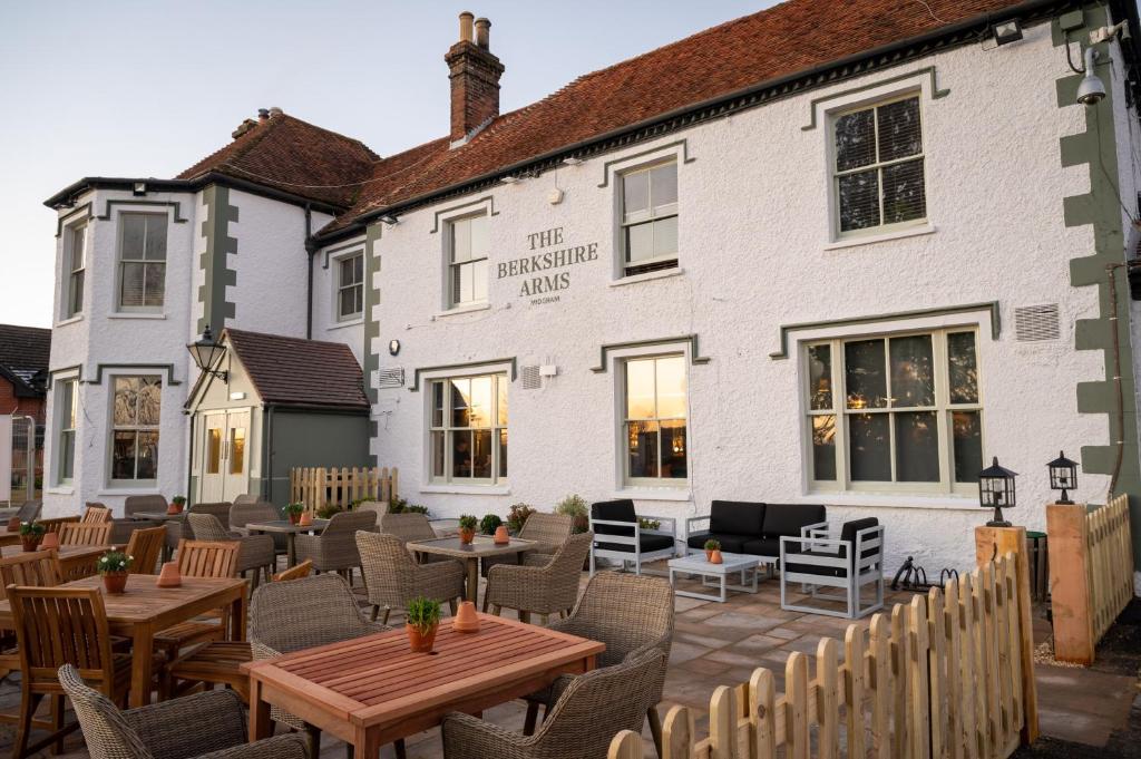 um restaurante com mesas e cadeiras em frente a um edifício em Berkshire Arms by Chef & Brewer Collection em Midgham