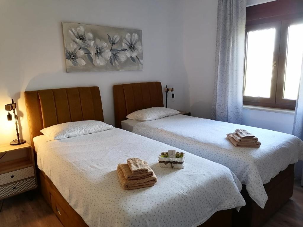 two beds in a room with towels on them at Apartment Grbin in Pula