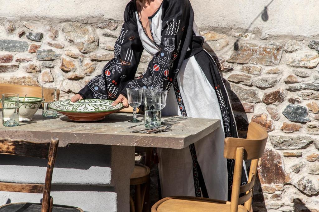 une femme debout à une table avec un bol dans l'établissement Onos Eco Living, à Mési