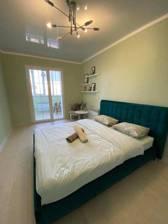 1 cama grande con cabecero azul en un dormitorio en Nur 5, en Uralsk