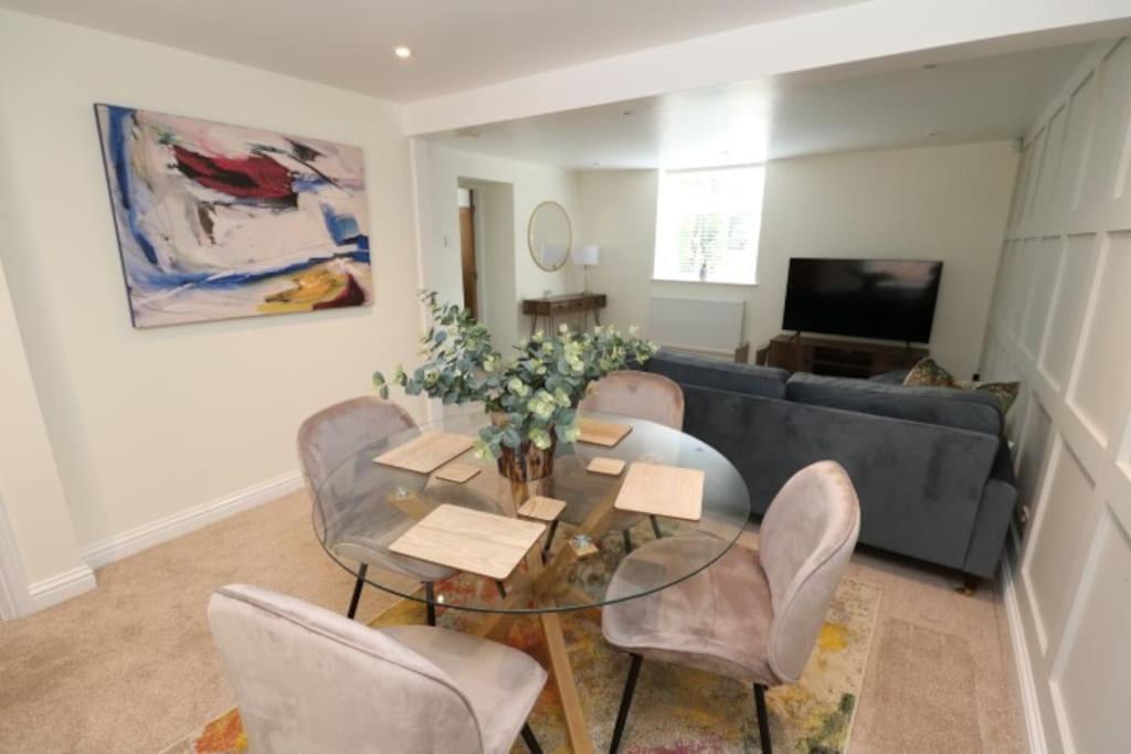 uma sala de estar com uma mesa e cadeiras e um sofá em The Cottage IH3ATL em Stockton-on-Tees