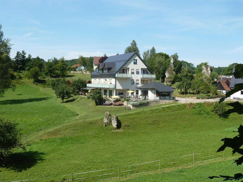 una gran casa blanca en un campo verde en Gästehaus Brütting, 