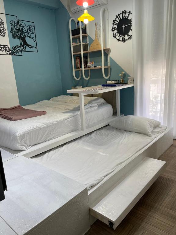 two beds in a room with blue walls at Oikiastudios in Patra