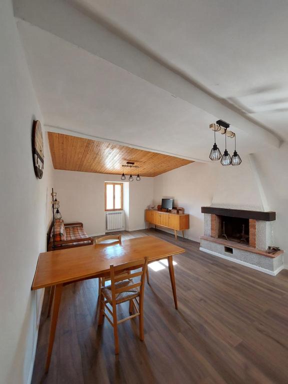 - un salon avec une table en bois et une cheminée dans l'établissement Bruni Apartments Arcidosso - Ginevra, à Arcidosso